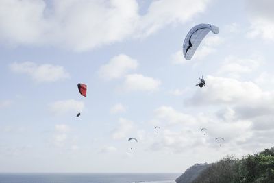 People paragliding over sea against sky