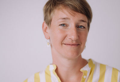Close-up portrait of young woman against gray background