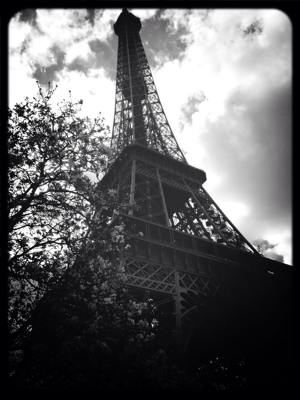 low angle view, transfer print, built structure, architecture, eiffel tower, sky, tower, auto post production filter, famous place, tall - high, culture, international landmark, metal, travel destinations, cloud - sky, tree, history, capital cities, tourism, travel
