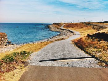 Road by sea against sky