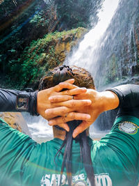 Portrait of young woman with hand in water