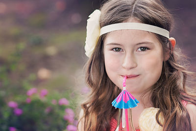 Close-up portrait of smiling girl drinking drink in garden