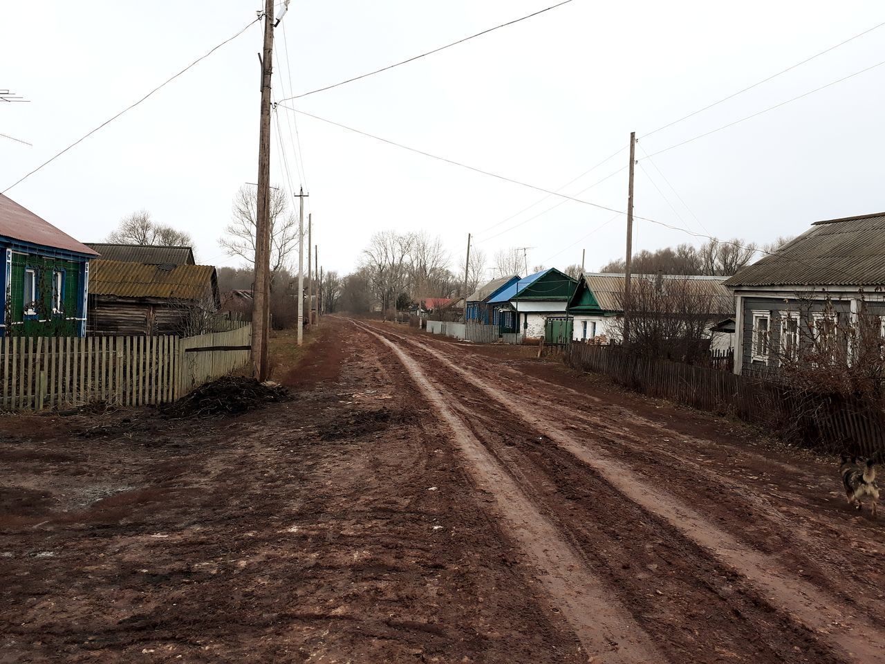 HOUSES BY RAILROAD TRACKS AGAINST SKY