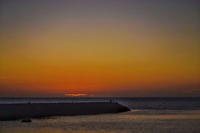 Scenic view of sea against orange sky