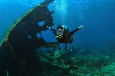 A woman doing scuba diving near a shipwreck