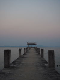 Wooden pier on sea against clear sky