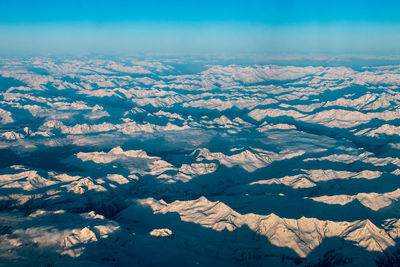 Aerial view of snowcapped mountains against sky