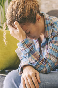 Side view of boy using mobile phone while sitting on sofa at home