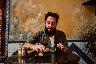 Portrait of young man sitting on table