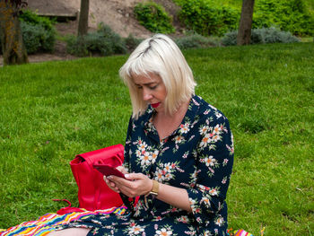 Young woman using mobile phone on field