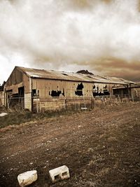 Abandoned building against cloudy sky