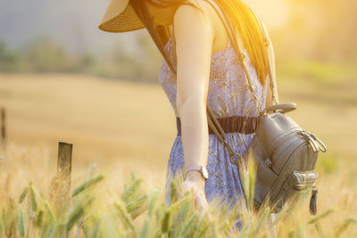 Midsection of woman walking on field