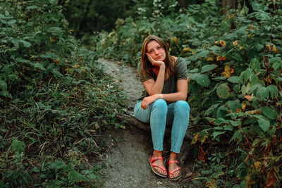 Portrait of young woman sitting on grass