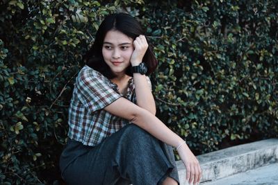 Portrait of young woman sitting outdoors