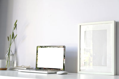 White vase on table against wall at home