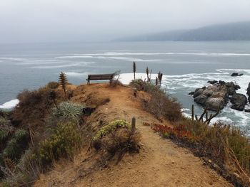 Empty bench overlooking calm sea