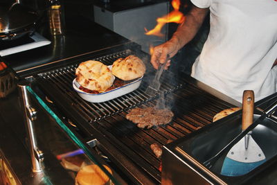 Midsection of man preparing food on barbecue grill