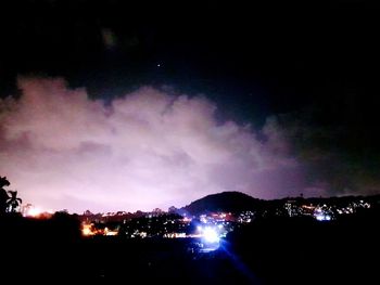 Illuminated city against sky at night