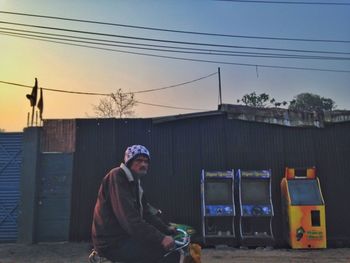 Side view of man standing on street against sky