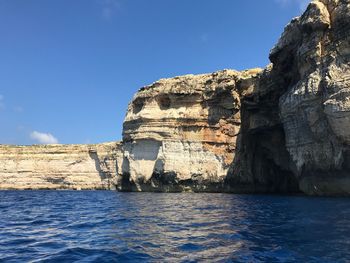 Sea by mountain against clear sky