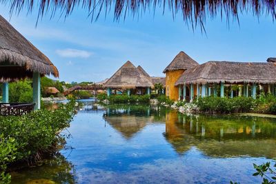 Scenic view of houses by lake against sky