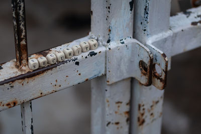 Close-up of toy blocks with text on rusty metal gate