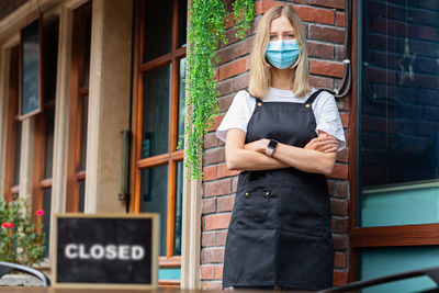 Caucasian waitress woman wearing medical mask, cafe closed. coronavirus covid-19 pandemic
