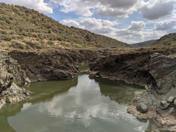 Scenic view of river amidst mountains against sky
