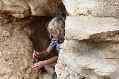 Boy sitting in cave