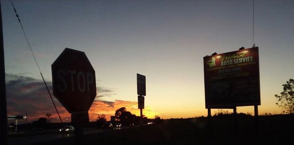 Silhouette of road sign at sunset