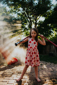 Young girl playing with host with sun shining through mist