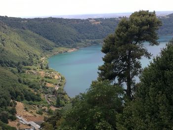 High angle view of lake amidst trees against sky