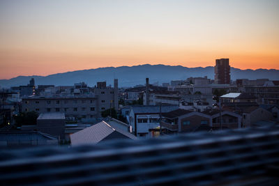 Buildings in city against sky during sunset