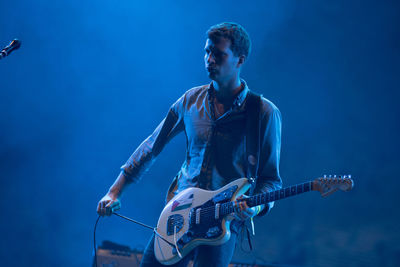 Man playing guitar at music concert