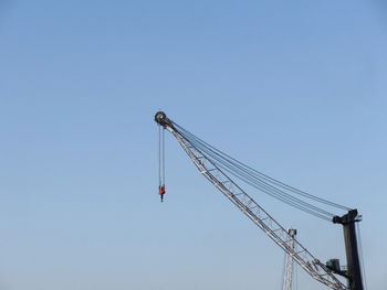 Low angle view of crane against clear sky