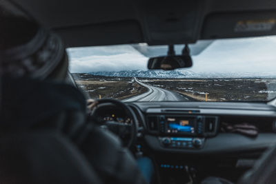 Rear view of vehicles on road seen through car windshield
