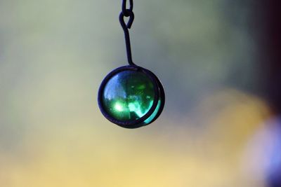 Close-up of green crystal ball hanging outdoors