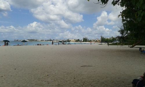 Scenic view of beach against cloudy sky