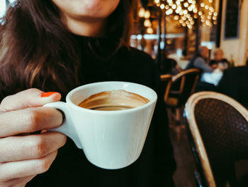 Midsection of woman holding coffee cup