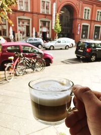 Close-up of hand holding drink in city