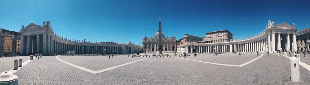 Panoramic view of buildings in city against clear blue sky