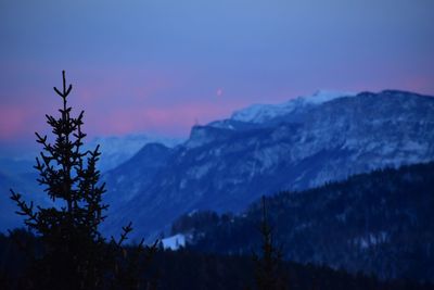 Scenic view of snowcapped mountains against sky at sunset