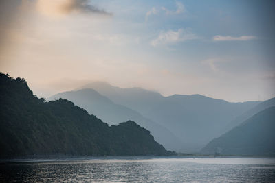 Scenic view of sea and mountains against sky