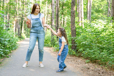 Full length of mother and daughter in forest