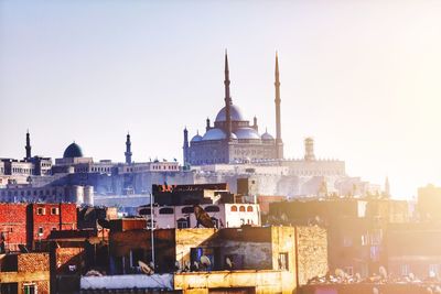 View of historic mosque in city against clear sky