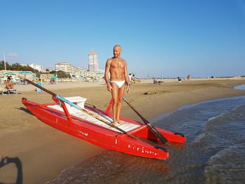 Man on beach against clear sky