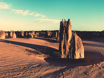 Rock formation on beach against sky