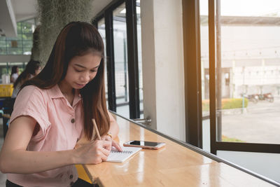 Young woman using mobile phone in office