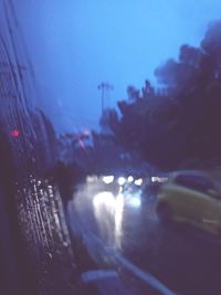 Cars on illuminated city seen through glass window