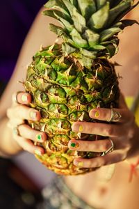 Midsection of woman holding pineapple